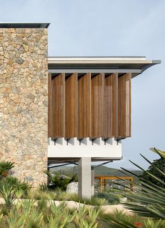 a building with wooden slats on the side of it and palm trees in front