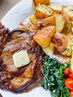 a white plate topped with meat, potatoes and veggies