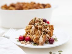 a white plate topped with fruit and granola next to a bowl of oatmeal