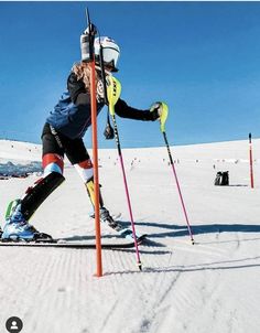 a person on skis leaning against a pole in the snow with poles attached to it