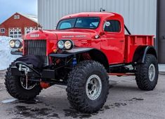 an old red truck parked in front of a building