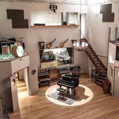 a living room filled with lots of furniture and musical instruments on top of hard wood floors