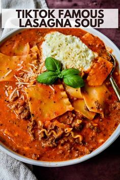 a white bowl filled with pasta and meat, topped with parmesan cheese on top