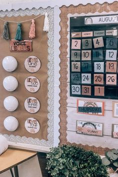 a bulletin board with calendars on it next to a potted plant and other decorations