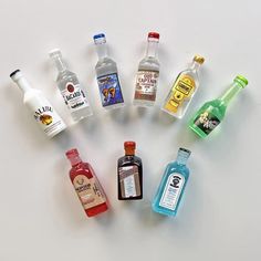 an assortment of liquor bottles arranged in the shape of a circle on a white surface