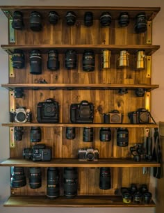 a wooden shelf filled with lots of cameras