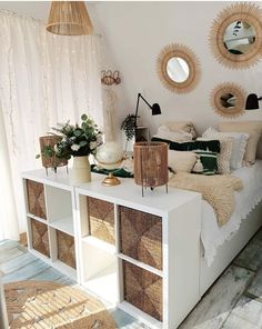 a bedroom with wicker baskets on the bed and round mirrors hanging from the ceiling