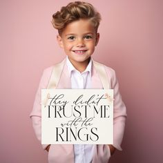 a little boy holding a sign that says they left the trust me with the rings