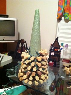 a pile of wine corks sitting on top of a glass table next to a computer