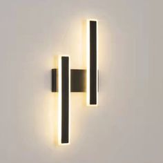 two lights that are on the wall next to each other in front of a white wall