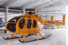 a yellow helicopter is parked in a hangar