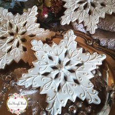 white snowflakes are sitting on top of a glass platter with other decorations