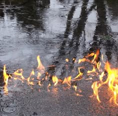 the fire is burning in the middle of the street and it looks like it's coming out of the water