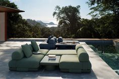 a couch and table in front of a swimming pool