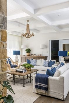 a living room filled with furniture and a chandelier hanging over the top of it