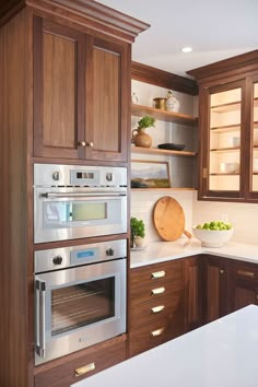 a kitchen with wooden cabinets and stainless steel oven in the center, surrounded by white counter tops