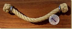 a close up of a rope on top of a wooden table with a badge attached to it