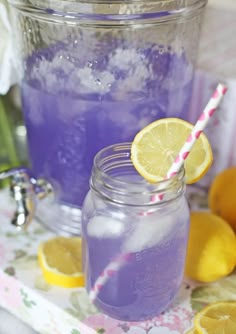 a purple drink in a mason jar with lemons around it