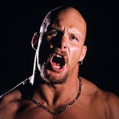 a shirtless man with his mouth open and chain around his neck is making an angry face