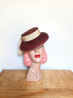 A lovely vintage 1940's tilt hat! Fashioned in chocolate brown straw. Beautiful styling! Featuring a small crown with a downturned wired brim. Styled with cream grosgrain ribbon, The matching backstrap keeps the hat in place on the wearer, The hat measures approx. 9 inches across. The interior is lined with a grosgrain sweatband. No labels. A darling tilt hat!  Please note the color may vary depending on your monitor   Designed to fit most head sizes due to the style. Sets atop the head.   In go Vintage Brown Top Hat For Kentucky Derby, Vintage Brimmed Boater Hat For Royal Ascot, Retro Mini Hats With Curved Brim For Vintage Events, Brimmed Brown Hat For Vintage Events, Fitted Vintage Brown Straw Hat, Brown Brimmed Hat For Vintage Events, Brown Vintage Straw Hat, Vintage Brown Brimmed Straw Hat, Vintage Straw Hat With Curved Brim For Royal Ascot