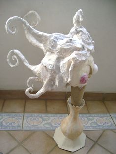 there is a sculpture that looks like an octopus on display in the room with tile flooring