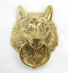 a golden metal dog head with a ring on it