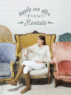 a woman sitting on top of a couch in front of some colorful chairs with writing on the wall behind her