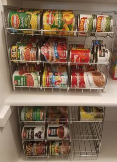 an organized pantry with canned food in the bottom shelf and other items on the bottom shelf