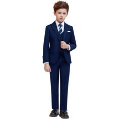 a young boy in a blue suit and black shoes standing with his hands on his hips