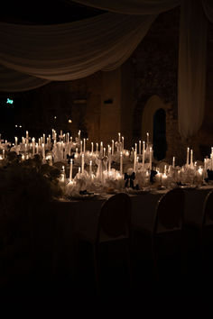 a long table covered in lots of white candles