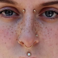 a woman with piercings on her nose and nose ring in front of her face