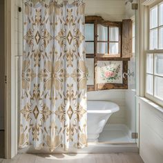 a bath room with a toilet and a shower curtain next to a window on the wall