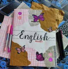 two notebooks with butterflies and the word english project written on them next to some pens