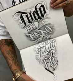 a man holding up two pieces of paper with tattoos on it and the words together