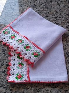 two pieces of crocheted cloth sitting on top of a granite counter next to each other