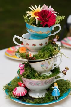 a stack of teacups with flowers in them sitting on top of each other