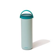 a white and blue water bottle sitting on top of a white table next to a green lid