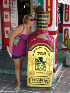 a woman standing next to a giant bottle