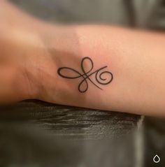 a small tattoo on the arm of a woman's left arm, with an infinite symbol