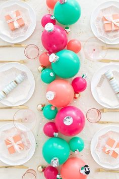 balloons and other decorations on a table with plates, forks and utensils in the background