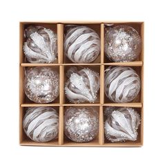 twelve silver and white ornaments in a wooden box