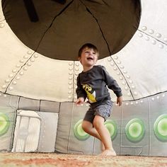 a young boy is running through an inflatable structure