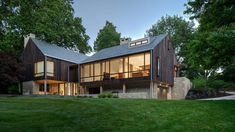 a large house sitting in the middle of a lush green field with lots of trees