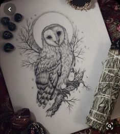 an owl sitting on top of a piece of paper next to a pen and ink