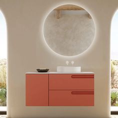 a bathroom with an oval mirror above the sink and red cabinetry on the wall