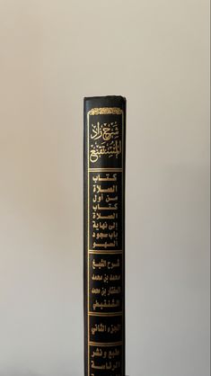 a tall black book with arabic writing on it