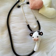 a stuffed cow is attached to a stethoscope on a white fur surface