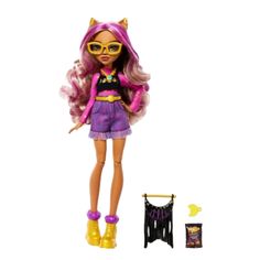 a doll with pink hair and yellow glasses next to a black cat purse, which is also wearing purple boots