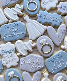 blue and white decorated cookies with wedding rings, engagement rings, and other items on them