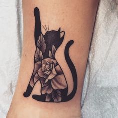 a black cat with a rose tattoo on its leg